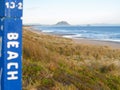 Long Papamoa beach view to Mount Maunganui from Beach access sign