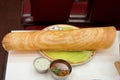 A Long paper thin Dosa served with coconut chutney and aromatic sambar.