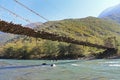 Long pedestrian suspension bridge over the mountain river Bzyb on a sunny autumn day in Abkhazia Royalty Free Stock Photo