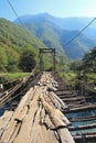 Long pedestrian suspension bridge over the mountain river Bzyb on a sunny autumn day in Abkhazia Royalty Free Stock Photo