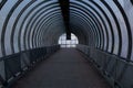 A long pedestrian tunnel with metal arches and glass design. Aerial pedestrian crossing over the highway, a dark empty tunnel no Royalty Free Stock Photo