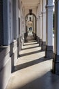 A long perspective view of a white architectural corridor with classical arches and columns Royalty Free Stock Photo