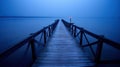 a long pier extending into the water at night with a light on