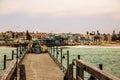 Long pier, walking people, residential houses on coastline of Sw