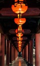 long pillars hold several lamps in the dark with red and green colors