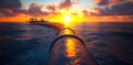 A long pipe is in the water with the sun setting behind it Royalty Free Stock Photo