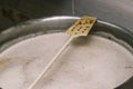 A long plastic stirrer for stirring food in a large pan. Brewing beer. The technology of making beer Royalty Free Stock Photo