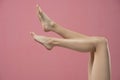 Long pretty smooth woman legs isolated on pink background Royalty Free Stock Photo