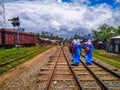 Noapara Railway Station, Noapar, Jashore, Bangladesh : July 27, 2019 : Long Rail Line, People And Two Girls With Bags Wearing Sch Royalty Free Stock Photo