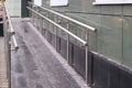 Long ramp. Metal smooth handrails. Building wall