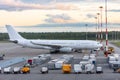 Long-range wide-body aircraft parked at the airport, in front of it is a food containers and mobile power supplies. Flight service