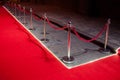 Long red carpet between rope barriers on entrance.