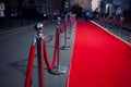 Long red carpet between rope barriers on entrance.