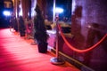 Long red carpet between rope barriers on entrance.