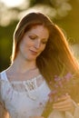 Long red hair woman in romantic sunset meadow