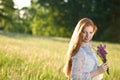 Long red hair woman in romantic sunset meadow