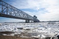 a long road bridge on the background of an ice drift on the river and a blue sky Royalty Free Stock Photo