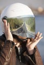 Long road reflection in mirrored tinted visor of helmet, portrait of unrecognizable European woman motorcyclist