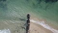 Long, rocky wave breaker on the beach with calm waves crashing against it on a Summer`s day at Point Lonsdale, Mornington