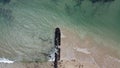 Long, rocky wave breaker on the beach with calm waves crashing against it on a Summer`s day at Point Lonsdale, Mornington