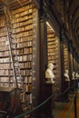 The Long Room interior Of The Old Library At Trinity College. Marble busts of great people and shelves with antique tomes Royalty Free Stock Photo