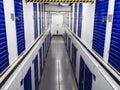 Long row of blue color doors of self storage facility. Service to keep safe extra belongings. Nobody. Selective focus. Clean and Royalty Free Stock Photo