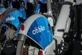 Long row of Citibike corporate sponsored bike share bicycles docked in a dock bay on a street in New York City.