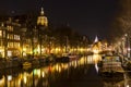 Long row of houses reflecting in a canal in Amsterdam