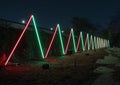 Long row of lighted neon triangles in Lightscape at the Fort Worth Botanic Garden in Texas.