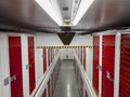 Long row of red color doors of self storage facility. Service to keep safe extra belongings. Nobody. Selective focus. Clean and Royalty Free Stock Photo