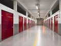 Long row of red color doors of self storage facility. Service to keep safe extra belongings. Nobody. Selective focus. Clean and