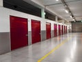 Long row of red color doors of self storage facility. Service to keep safe extra belongings. Nobody. Selective focus. Clean and