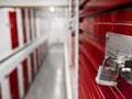 Long row of red color doors of self storage facility. Service to keep safe extra belongings. Nobody. Selective focus. Clean and