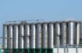 Long row of stainless storage silos for liquids and differents types of free flowing raw materials