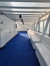 Long row of white benches next to each other in a white ship corridor Royalty Free Stock Photo