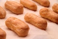 Long rows Eclair shells. Eclairs candy paper. The process of making cakes.