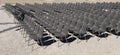 Long rows of empty gray plastic chairs geometrically arranged under the sun. Side view, copy space. Royalty Free Stock Photo