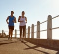 In it for the long run. a young couple jogging together the promenade. Royalty Free Stock Photo