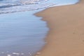 Long sea waves with foam on the sandy beach. Royalty Free Stock Photo