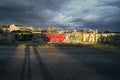 Long shadows against a fence covered in graffiti at sunset