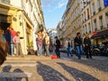 Long shadows on cobbles street and tourists on street corner in Montmartre district Royalty Free Stock Photo