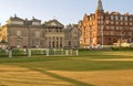 Long shadows falling across manicured lawns in front of historic buildings on St Andrews