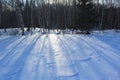 Long shadows from the late afternoon sun cast on the spotless snow in wintertime. Royalty Free Stock Photo