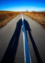 Long shadows of people on the road Royalty Free Stock Photo