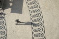 Long shadows of people on a square with pattern of paving stones in Lisbon