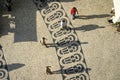 Long shadows of people on a square with pattern of paving stones in Lisbon