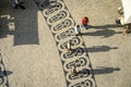 Long shadows of people on a square with pattern of paving stones in Lisbon