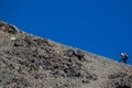 Blurred runner climbing difficult slope against blue sky