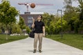 Long Shot of Casually Dressed Man With a Basketball and Gym Bag
