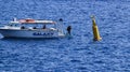 A long shot of a dive boat and diver entering the sea